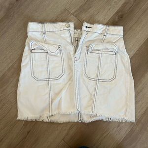 White with black outline denim mini skirt with front pockets.